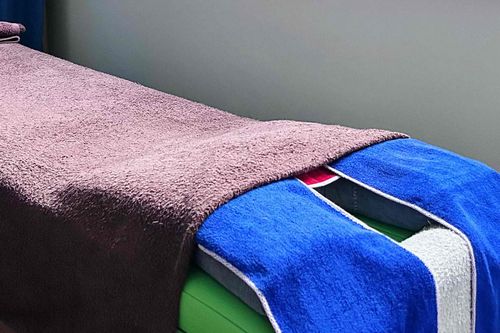 Private treatment bed covered with clean linens